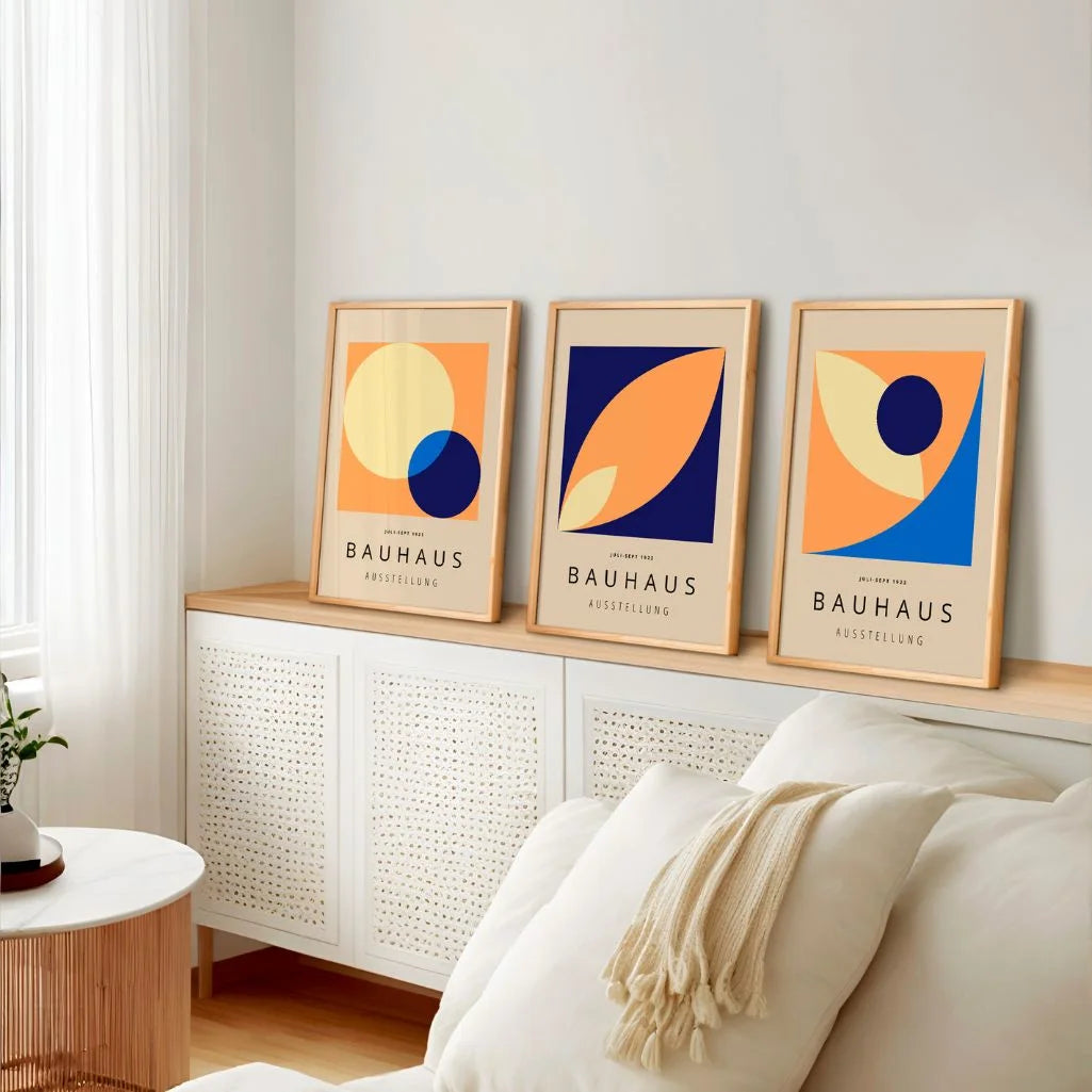 orange and navy bauhaus poster set with cream and light blue tones in modern dining area